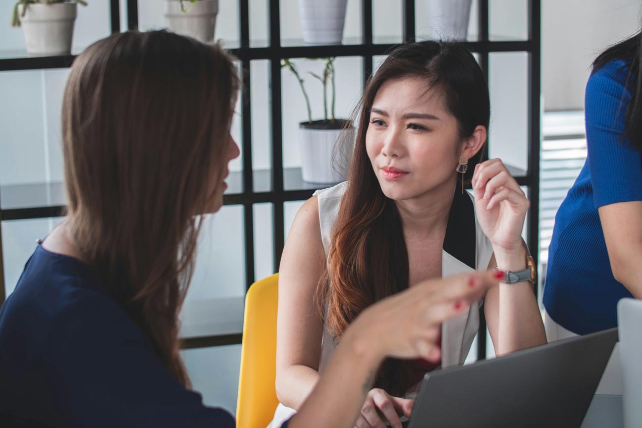 Image of two women one who is a developer and another a client discussing a project.